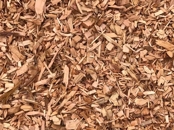 Close-up texture of cedar wood chips mulch in light brown tones